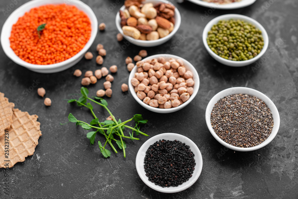 Superfoods on a gray background with copy space. Nuts, beans, greens and seeds. Healthy vegan food Superfoods on a gray background with copy space. Nuts, beans, greens and seeds. Healthy vegan food