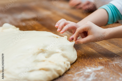 Young children make dough products. Hands closeup