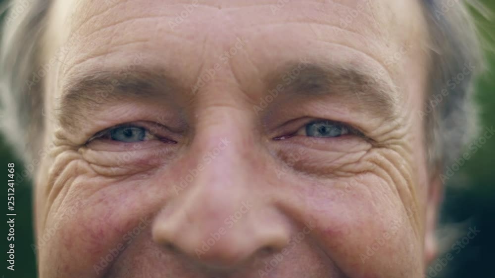 Close up of an elderly white man's blue eyes staring into the camera whilst smiling - fathers eyes Close up of an elderly white man's blue eyes staring into the camera whilst smiling - fathers eyes