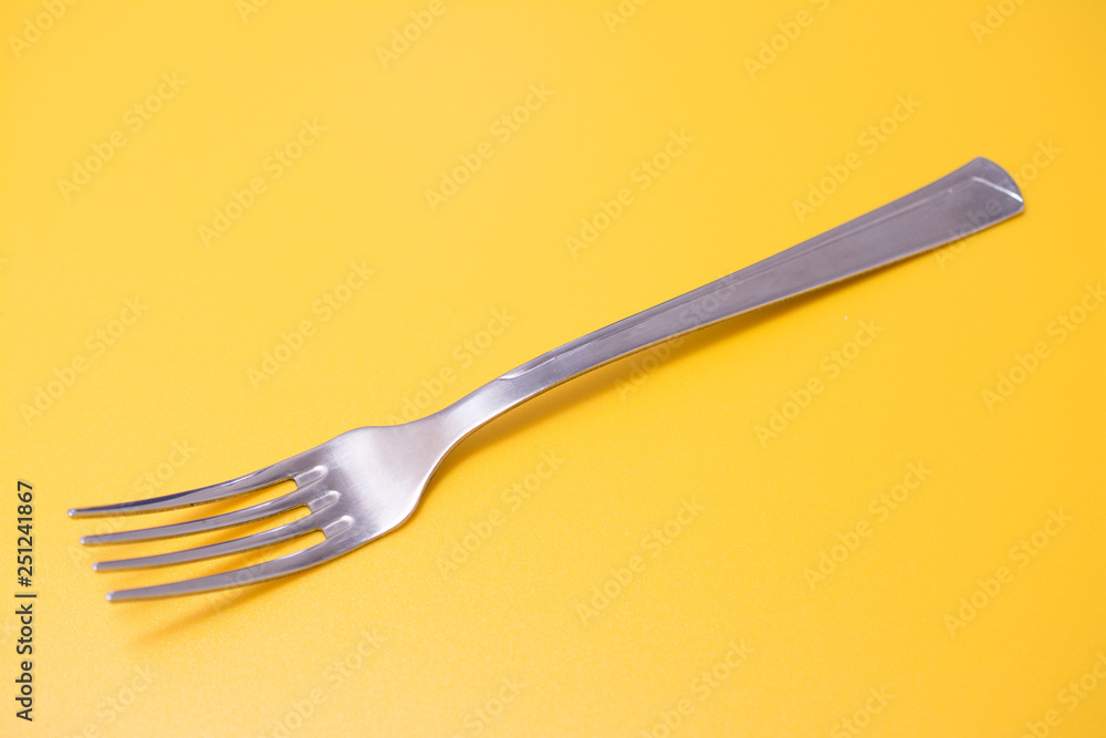 Fork isolated on yellow background, studio shot Fork isolated on yellow background, studio shot