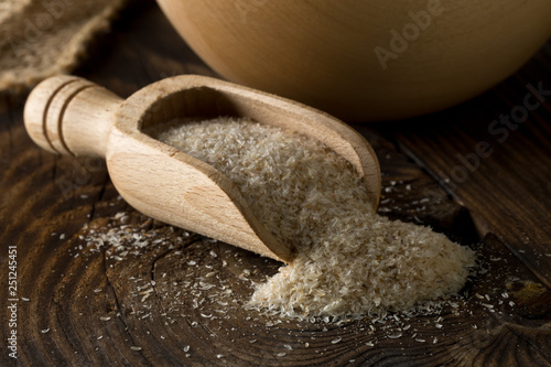 Billede på lærred Heap of psyllium husk also called isabgol in wooden scoop and bowl on table