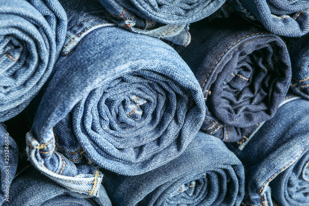 Fototapeta premium Background of a stack rolled jeans, space for text