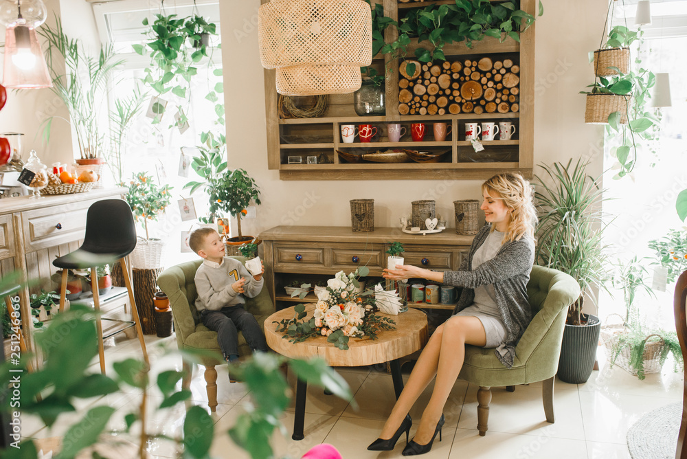 Mom and son with flowers in caffe. Son give flowers to mother. cute family. International women`s day, 8 march celebrating Mom and son with flowers in caffe. Son give flowers to mother. cute family. International women`s day, 8 march celebrating