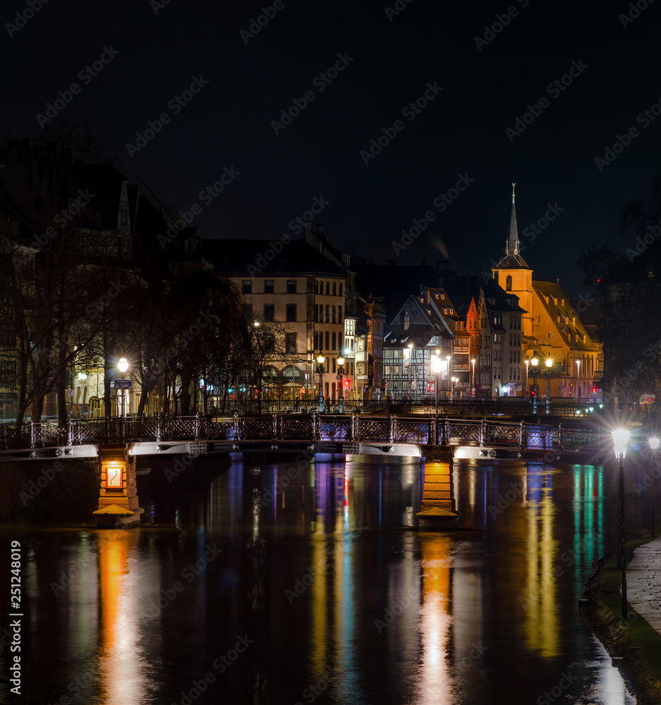 Naklejka premium Saint Nicolas church in Strasbourg night view with reflections in the river Ill