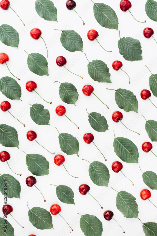 Fresh red cherry and leaf pattern on white background. Spring and summer concept. Flat lay, top view, copy space Fresh red cherry and leaf pattern on white background. Spring and summer concept. Flat lay, top view, copy space