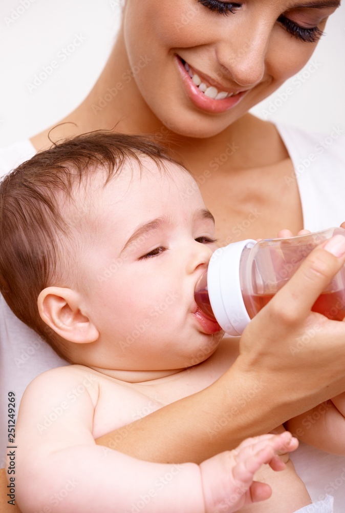 Sleepy baby drinking tea from feeding bottle Sleepy baby drinking tea from feeding bottle