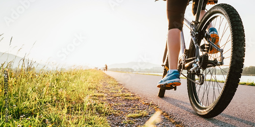 Foto Woman feet on bycikle pedal in sunset light