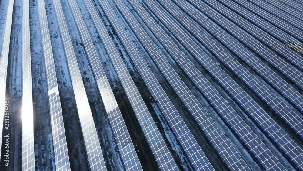 Aerial view of the industrial solar power station (solar electricity plant) in a course of building on a winter sunny day Aerial view of the industrial solar power station (solar electricity plant) in a course of building on a winter sunny day