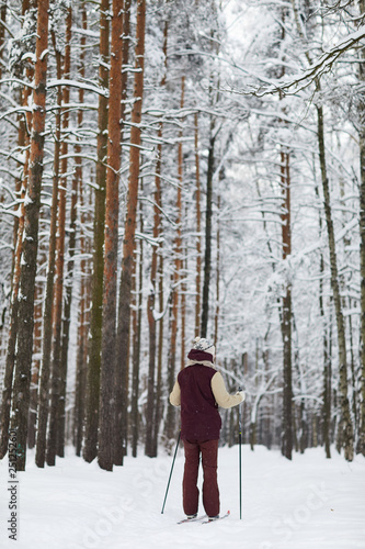 Wide angle portrait of active young man skiing in forest enjoying winter, copy space