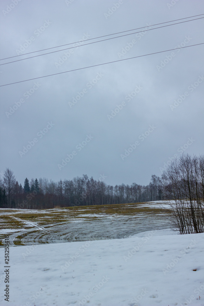 Empty Countryside Landscape in Cloudy Winter Day with Snow Partly Covering the Ground and Fog Empty Countryside Landscape in Cloudy Winter Day with Snow Partly Covering the Ground and Fog