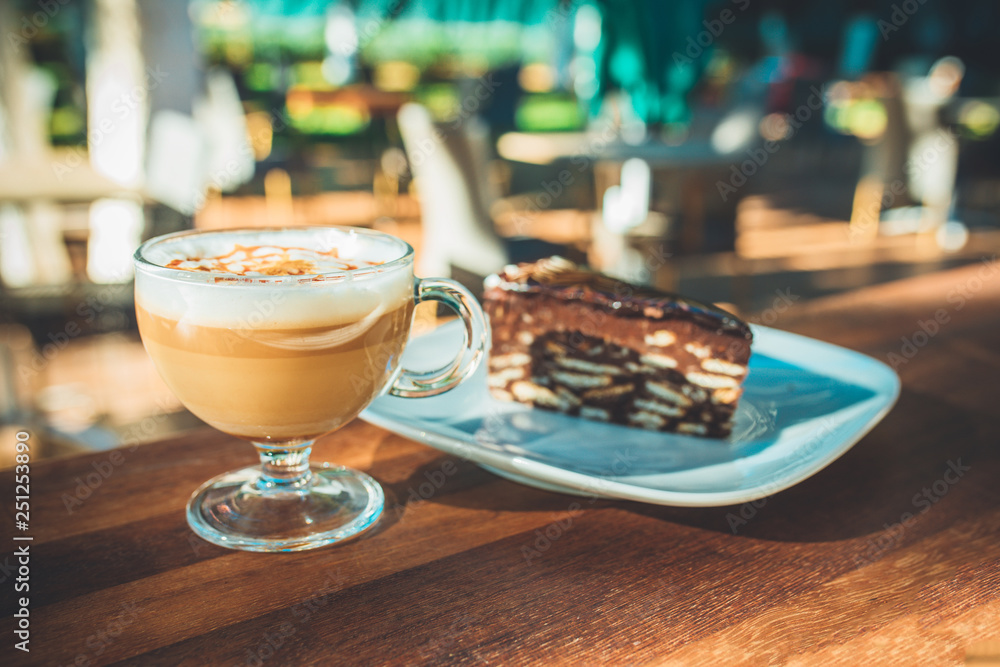 Latte coffee and cake on wooden table at outdoor