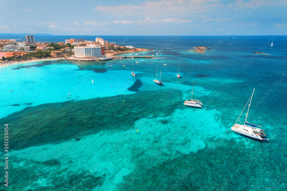 Aerial view of boats and luxury yachts in the clear sea at sunset in summer in Mallorca, Spain. Colorful seascape with lagoon, azure water, sandy beach, blue sky. Balearic islands. Top view. Travel Aerial view of boats and luxury yachts in the clear sea at sunset in summer in Mallorca, Spain. Colorful seascape with lagoon, azure water, sandy beach, blue sky. Balearic islands. Top view. Travel
