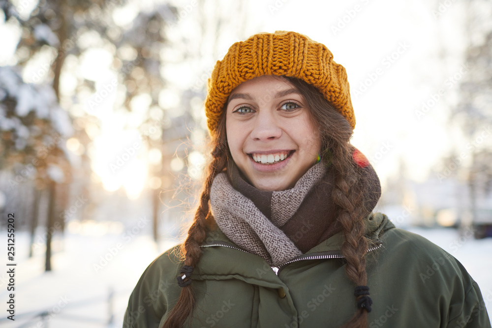 Head and shoulders portrait of smiling young woman posing outdoors in sunlight, copy space Head and shoulders portrait of smiling young woman posing outdoors in sunlight, copy space