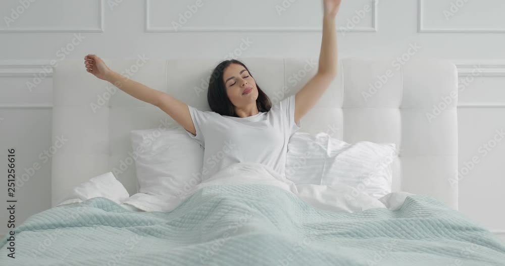 Young girl stretching in bed early morning after waking up Young girl stretching in bed early morning after waking up