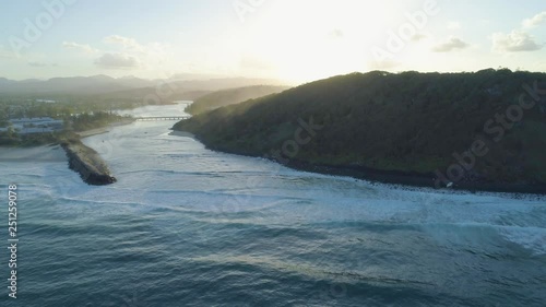 Slow rise above Tallebudgera Creek and Burleigh Head National Park at sunset