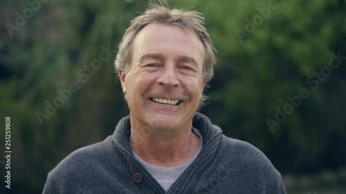 Portrait of a mature adult white male looking into the camera and then smiling