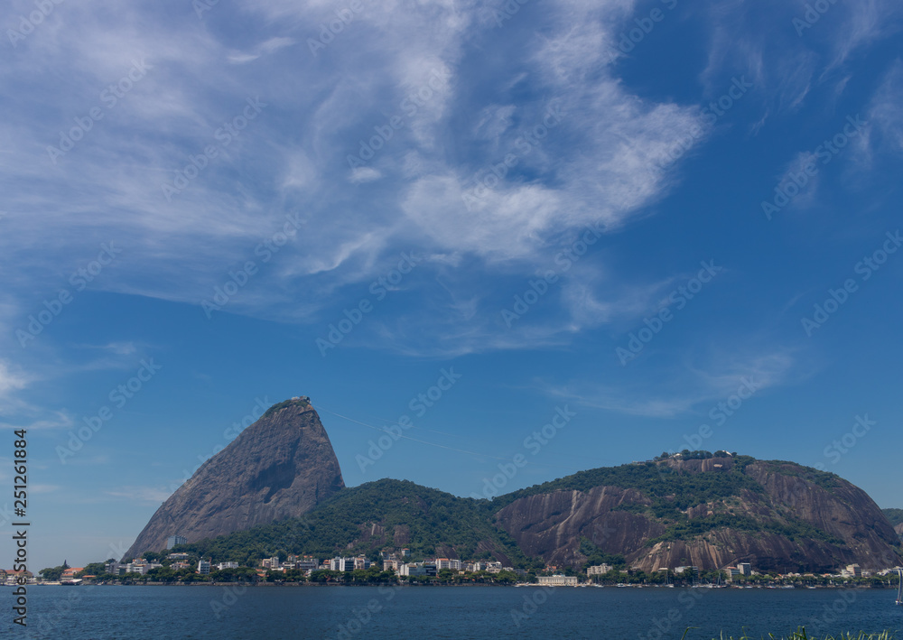 Beautiful panoramic view of the Sugar Loaf mountain in Rio de Janeiro, Brazil, on a beautiful and relaxing sunny day with blue sky and white clouds