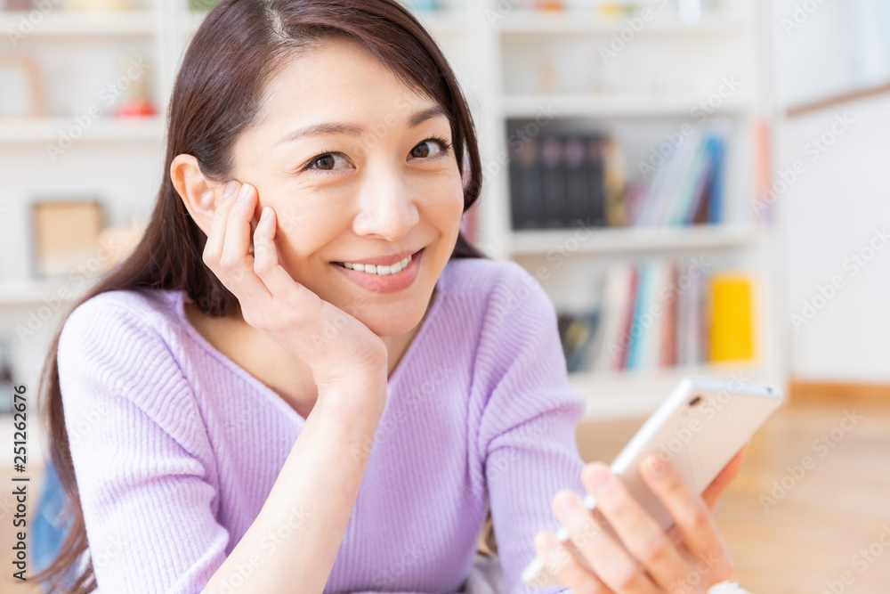 部屋でスマホを見る女性 部屋でスマホを見る女性