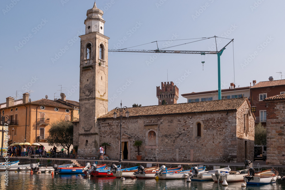 Obraz premium Lazise, Italy. Church of San Nicolò and boats moored in the marina.