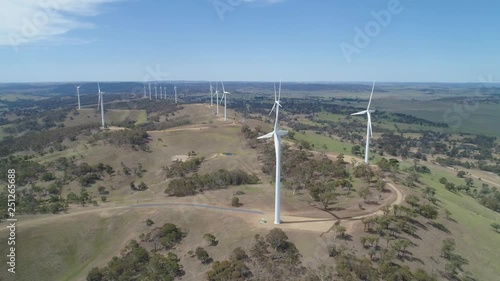 Aerial pan across wind turbines in wind farm countryside. New South Wales, Australia photo