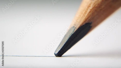 extreme close up of architect or artist draws a line in pencil. schoolboy drawing a flat line with a black pencil. Artists hands drawing wooden pencil writes line on paper. tracking shot