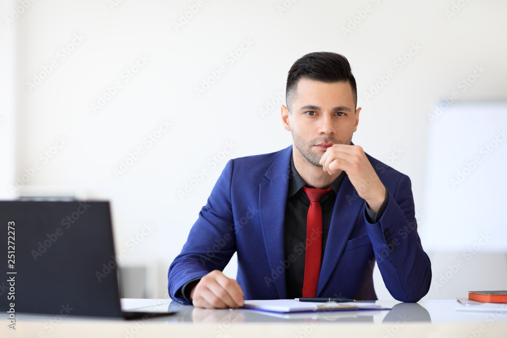 Portrait of thoughtful businessman sitting at his desk in the office Portrait of thoughtful businessman sitting at his desk in the office