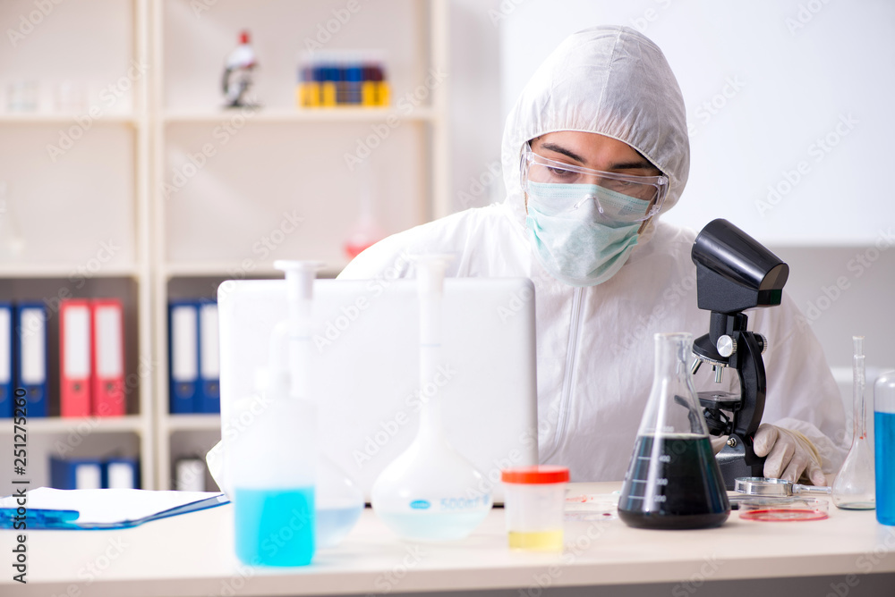 Young handsome chemist working in the lab Young handsome chemist working in the lab