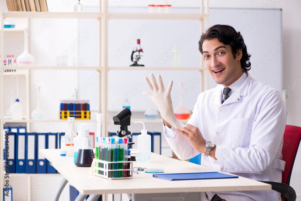 Young handsome chemist working in the lab Young handsome chemist working in the lab