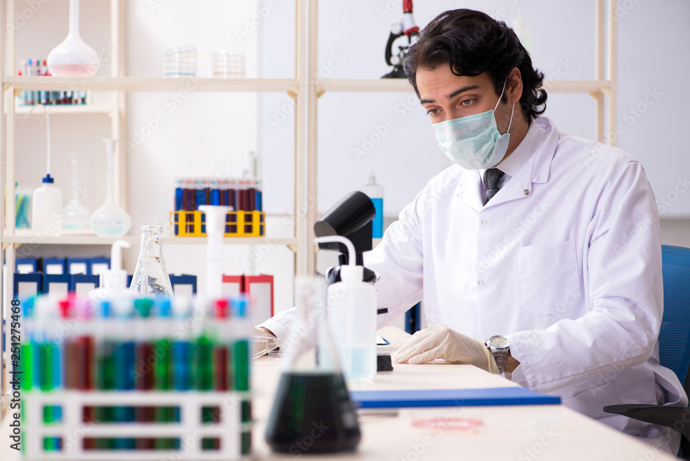 Young handsome chemist working in the lab Young handsome chemist working in the lab
