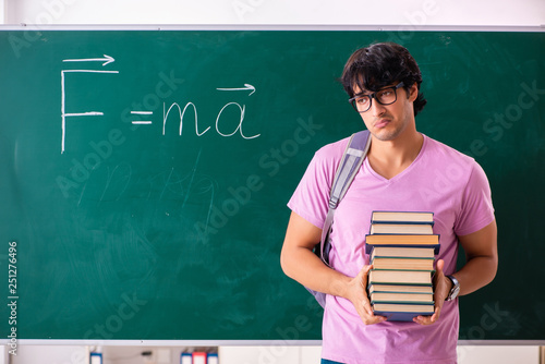 Young male physic standing in front of the green board photo