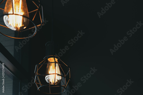 Beautiful vintage luxury light lamp hanging decor glowing in dark. Retro filter effect style. © jakkapan
