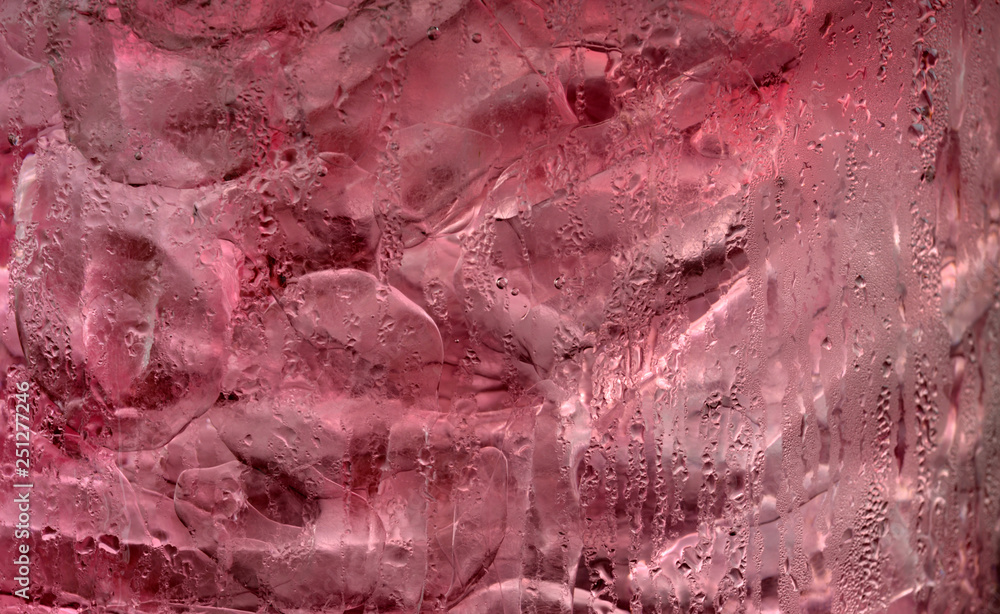Ice cube in pink soft drink Ice cube in pink soft drink