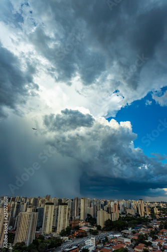 Dark and dramatic clouds of rain. Airplane taking off with storm clouds. Very heavy rain sky in the city of Sao Paulo, Brazil South America.  © Ranimiro