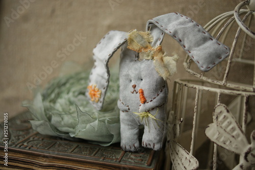 Handmade Bunny Rabbit. Gray textile rabbit with a carrot. Easter decor for the interior. Toy hare fabric. 