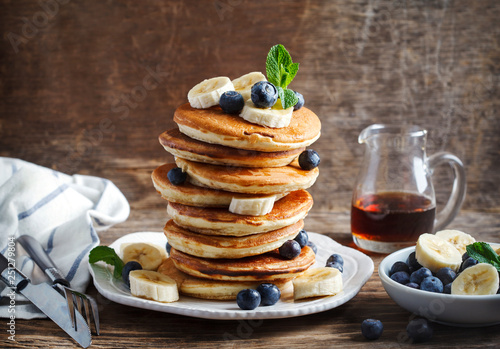 Pancakes with banana, blueberry and maple syrup for breakfast photo