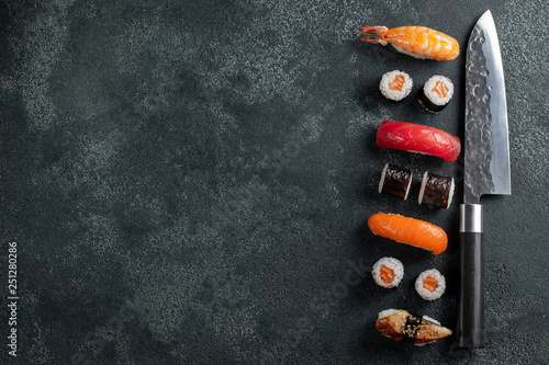 Different Sushi with Japanese knife on concrete. photo