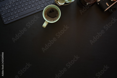 Dark leather office photography desk table with keyboard tablet and vintage camera
