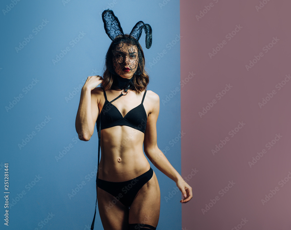 Sexy young woman in black lace lingerie and stockings preparing for Easter.  Sexy brunette posing nude wearing bunny ears. Woman easter. Nude girl with  perfect body are getting ready for holiday. Stock