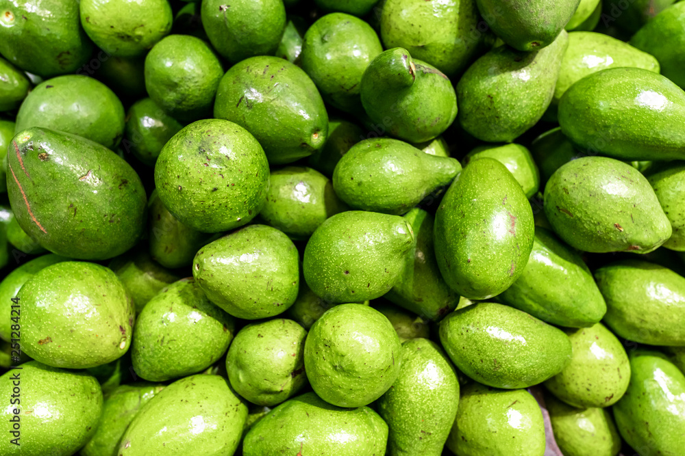 Fresh organic exotic green avocado on a local food market, Bali island. Avocado background. Fresh organic exotic green avocado on a local food market, Bali island. Avocado background.