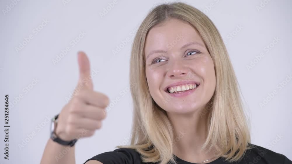 Face of young happy blonde woman giving thumbs up Face of young happy blonde woman giving thumbs up