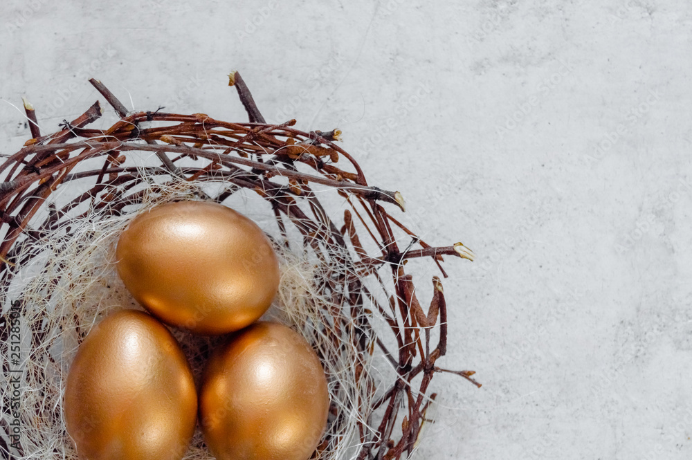 Fototapeta premium Golden Easter Eggs in birds Nest over rustic background. Easter Holiday concept abstract background copyspace top view several objects.Close up view