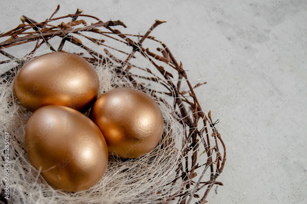 Golden Easter Eggs in birds Nest over rustic background. Easter Holiday concept abstract background copyspace top view several objects.Close up view Golden Easter Eggs in birds Nest over rustic background. Easter Holiday concept abstract background copyspace top view several objects.Close up view