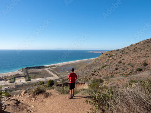 Boy looking toward ocean at trailhead, Chumash and Mugu Peak trail, Point Mugu State Park, Ventura County, California, USA