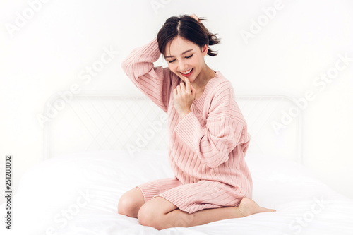 Portrait of happy smile asia woman enjoy and relax on the bed in bedroom at home.asian beauty