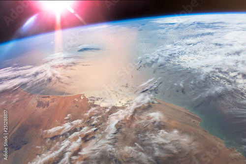 Fototapeta Naklejka Na Ścianę i Meble -  The Sun's glint radiates off the Atlantic Ocean above the African Mauritania. Elements of this image furnished by NASA.