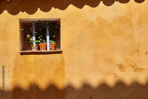 window on yellow stone wall