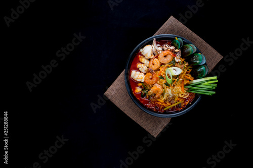 Korean food, Jampong, spicy noodle seafood in black bowl for korean menu style. photo