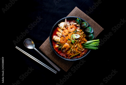 Korean food, Jampong, spicy noodle seafood in black bowl for korean menu style. photo