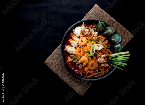 Korean food, Jampong, spicy noodle seafood in black bowl for korean menu style. photo