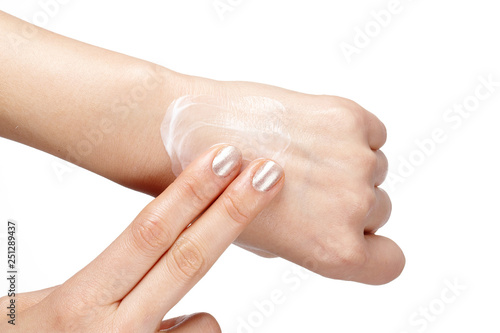 Woman applies cream on her hands isolated on white background.
